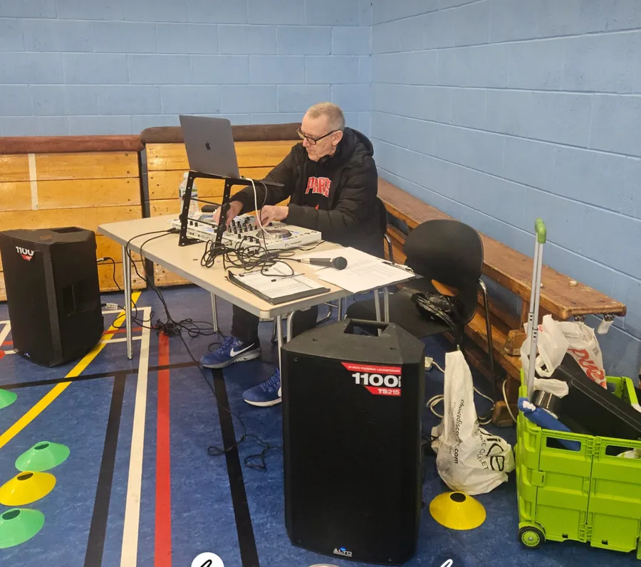 A man seated at the DJ decks, mixing gallery image 2