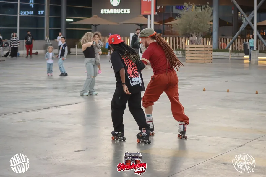 2 roller skaters, on a lap around the rink gallery image 4
